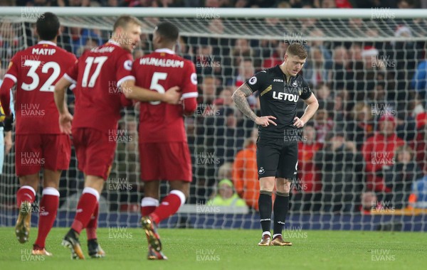 261217 - Liverpool v Swansea City - Premier League - Dejected Alfie Mawson of Swansea is surrounded by celebrating Liverpool players after the 4th goal