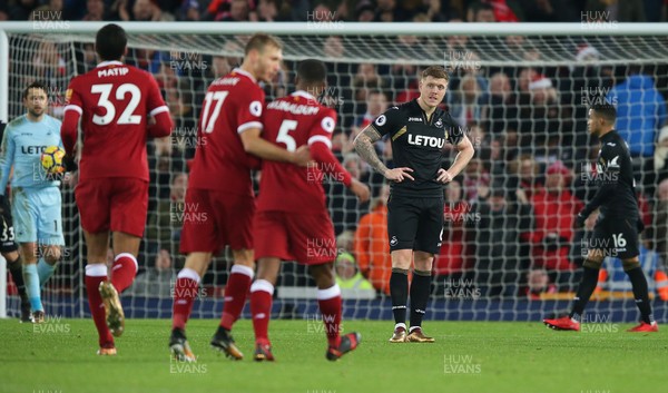 261217 - Liverpool v Swansea City - Premier League - Dejected Alfie Mawson of Swansea is surrounded by celebrating Liverpool players after the 4th goal whilst Goalkeeper Lukasz Fabianski  of Swansea picks up the ball from the net