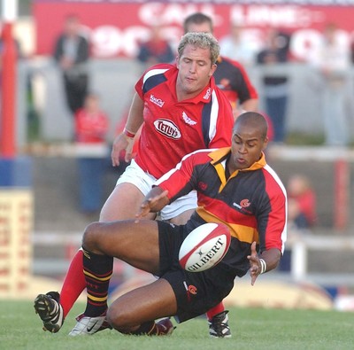 060903 - Llanelli Scarlets v Newport Gwent Dragons - Celtic League - Dragons' Nathan Brew pounces on ball under pressure from Leigh Davies