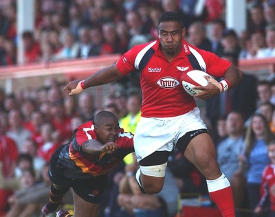 060903 - Llanelli Scarlets v Newport Gwent Dragons - Celtic League - Scarlets' Salesi Finau beats tackle by Nathan Brew