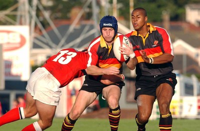 060903 - Llanelli Scarlets v Newport Gwent Dragons - Celtic League - Dragons' Craig Warlow is tackled by Leigh Davies