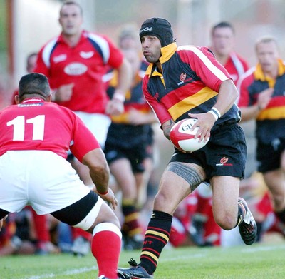 060903 - Llanelli Scarlets v Newport Gwent Dragons - Celtic League - Dragons' Jason Forster looks for a way past Salesi Finau 