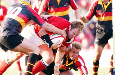 060903 - Llanelli Scarlets v Newport Gwent Dragons - Celtic League - Scarlets' Scott Quinnell dives over to score despite tackle by Craig Warlow