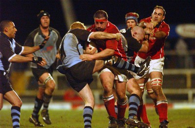 040203 - Llanelli v Cardiff - Welsh Premiership - Llanelli's John Davies is tackled by Martyn Williams