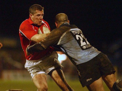 040203 - Llanelli v Cardiff - Welsh Premiership - Llanelli's Guy Easterby is tackled by Pieter Muller