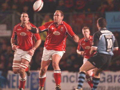 040203 - Llanelli v Cardiff - Welsh Premiership - Llanelli's Scott Quinnell juggles ball as Iestyn Harris (rt) looks to tackle