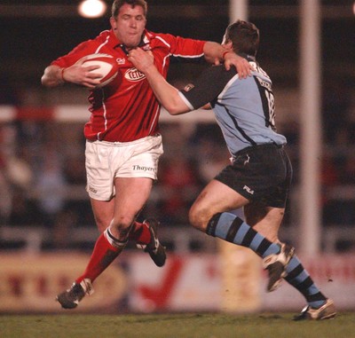 040203 - Llanelli v Cardiff - Welsh Premiership - Llanelli's Leigh Davies gets past tackle of Iestyn Harris