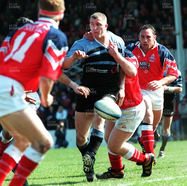 130497 - Llanelli v Cardiff - Leigh Davies kicks ahead as he is tackled by Sean Gale