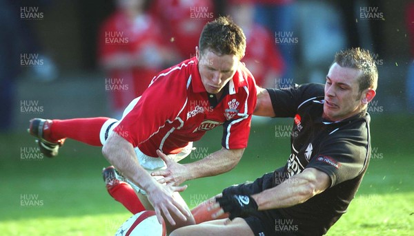 050403 - Llanelli v Neath - Principality Cup Quarter Final - Llanelli's Barry Davies touches down to score try despite challenge by Gareth Morris