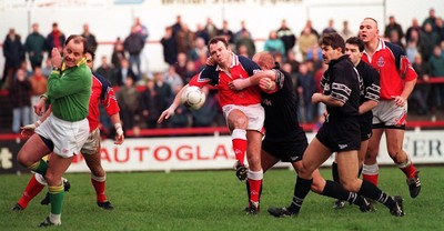 251195 - Llanelli v Neath - Ieuan Evans of Llanelli kicks as he's tackled by Justin Burnell