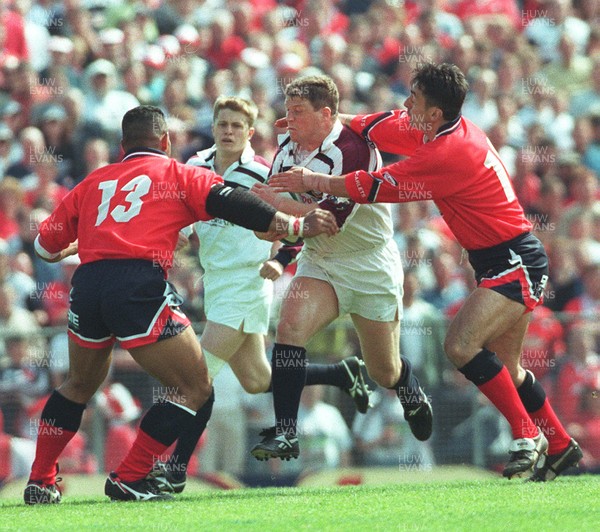 150599 - Llanelli v Swansea - SWALEC Cup Final -  Swansea's Scott Gibbs is caught by Nigel Davies (rt) and Salesi Finau