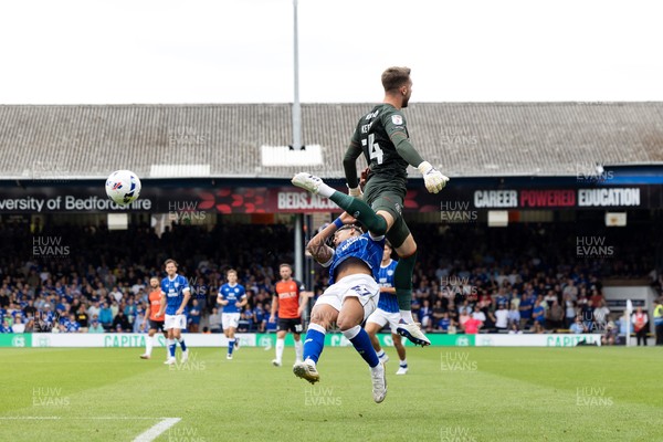 230825 - Luton Town v Cardiff City - Sky Bet League 1 - Luton Town’s Josh Keeley leaps into Cardiff Cty’s Callum Robinson