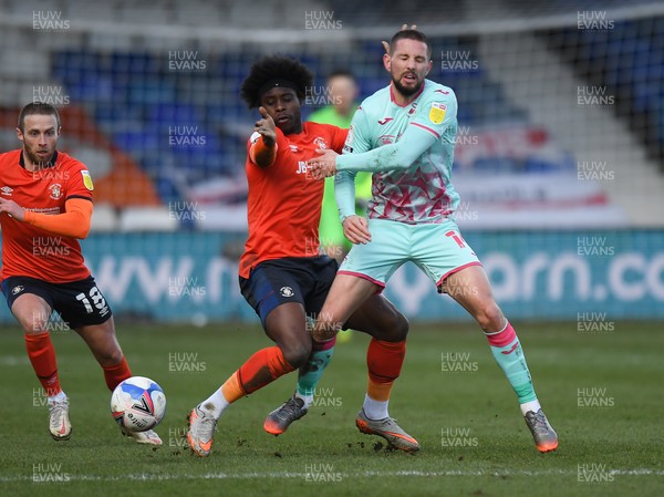 130321 - Luton Town v Swansea City - Sky Bet Championship - Conor Hourihane of Swansea City battles for possession with Pelly Ruddock Mpanzu of Luton Town