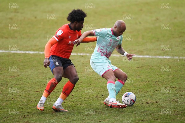 130321 - Luton Town v Swansea City - Sky Bet Championship - Andre Ayew of Swansea City holds off the challenge from Pelly Ruddock Mpanzu of Luton Town