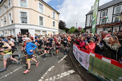 110622 - Whole Earth Man v Horse Race - Competitors take part in the Whole Earth Man v Horse race in Llanwrtyd Wells, Wales Running for over 40 years, Man v Horse is an epic 225-mile challenge which pits humans against horses across a multi-terrain course It is being staged for the first time after a two year absence due to the Covid Pandemic Picture shows runners at the start 