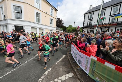 110622 - Whole Earth Man v Horse Race - Competitors take part in the Whole Earth Man v Horse race in Llanwrtyd Wells, Wales Running for over 40 years, Man v Horse is an epic 225-mile challenge which pits humans against horses across a multi-terrain course It is being staged for the first time after a two year absence due to the Covid Pandemic Picture shows runners at the start 