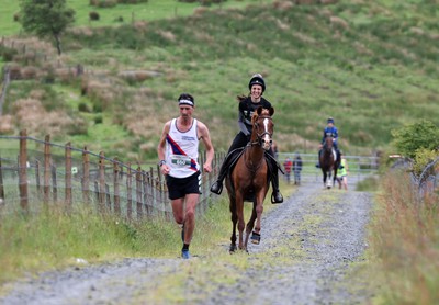 110622 - Whole Earth Man v Horse Race - Competitors take part in the Whole Earth Man v Horse race in Llanwrtyd Wells, Wales Running for over 40 years, Man v Horse is an epic 225-mile challenge which pits humans against horses across a multi-terrain course It is being staged for the first time after a two year absence due to the Covid Pandemic