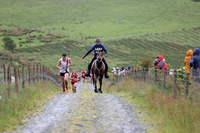 110622 - Whole Earth Man v Horse Race - Competitors take part in the Whole Earth Man v Horse race in Llanwrtyd Wells, Wales Running for over 40 years, Man v Horse is an epic 225-mile challenge which pits humans against horses across a multi-terrain course It is being staged for the first time after a two year absence due to the Covid Pandemic