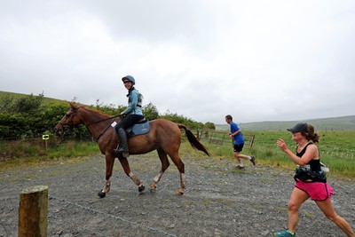 110622 - Whole Earth Man v Horse Race - Competitors take part in the Whole Earth Man v Horse race in Llanwrtyd Wells, Wales Running for over 40 years, Man v Horse is an epic 225-mile challenge which pits humans against horses across a multi-terrain course It is being staged for the first time after a two year absence due to the Covid Pandemic