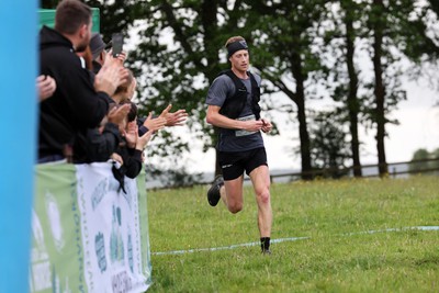 110622 - Whole Earth Man v Horse Race - Competitors take part in the Whole Earth Man v Horse race in Llanwrtyd Wells, Wales Running for over 40 years, Man v Horse is an epic 225-mile challenge which pits humans against horses across a multi-terrain course It is being staged for the first time after a two year absence due to the Covid Pandemic Picture shows the first competitor to reach the finish, Ricky Lightfoot