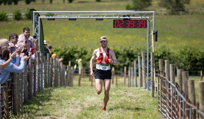 130626 - Man v Horse, Llanwrytd Wells - First runner across the finish line Daniel Connolly from Keswick comes home in the annual Man v Horse Race held at Llanwrytd Well, Powys, Wales He was eventually beaten by rider Rachel Lima from Pontypridd on her horse Zamell
