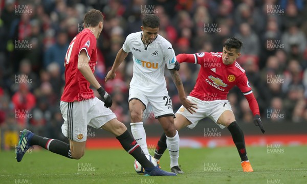 310318 - Manchester United v Swansea City - Premier League -  Kyle Naughton of Swansea is tackled by Nemanja Matic and Alexis Sanchez of Manchester United