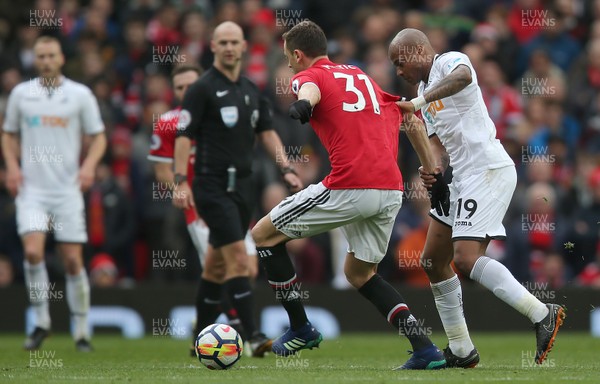 310318 - Manchester United v Swansea City - Premier League -  Andre Ayew of Swansea tackles Nemanja Matic of Manchester United