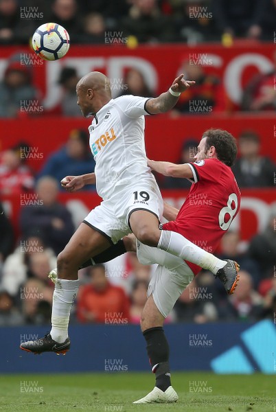 310318 - Manchester United v Swansea City - Premier League -  Andre Ayew of Swansea heads the ball away from Juan Mata of Manchester United