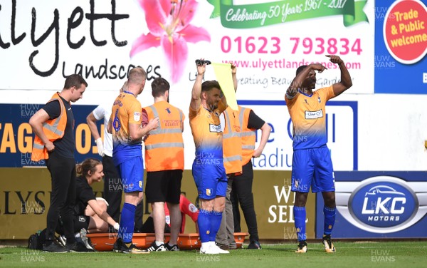 040818 - Mansfield Town v Newport County - League 2 - Assistant Referee is treated before being stretchered off As Alex MacDonald and Krystian Pearce of Mansfield Town call for a replacement