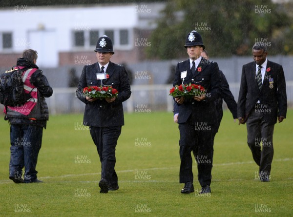 101118  - Metropolitan Police v Newport County - FA Cup First Round -  Police carry wreaths from the pitch in remembrance of Armistice