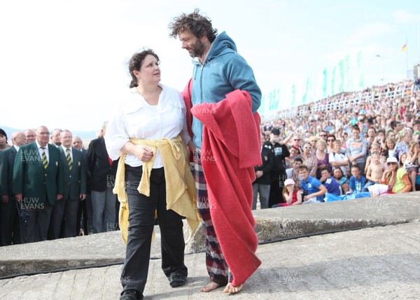 22.04.11 - The Passion with Michael Sheen, Aberavon Beach, south Wales. Michael Sheen playing the part of The Schoolteacher comes to the aid of a suicide bomber during his performance in The Passion on Aberavon Beach, south Wales 