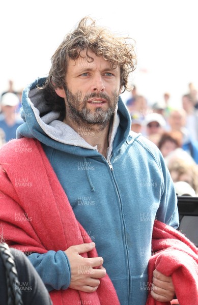 22.04.11 - The Passion with Michael Sheen, Aberavon Beach, south Wales. Michael Sheen playing the part of The Schoolteacher comes to the aid of a suicide bomber during his performance in The Passion on Aberavon Beach, south Wales 