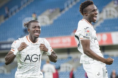 131026 - Millwall v Swansea City - Sky Bet Championship -   Moussa Kounfolo Yeo of Swansea City and Joseph Opoku of Swansea City celebrate with fans