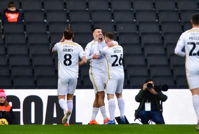 140226 - Milton Keynes Dons v Newport County - Sky Bet League 2 - Aaron Collins of MK Dons (centre) celebrates scoring the first goal with Alex Gilbey (left) and Ben Wiles of MK Dons 