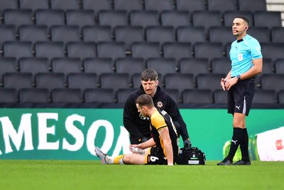 140226 - Milton Keynes Dons v Newport County - Sky Bet League 2 - Ciaran Brennan of Newport County is treated for an injury 