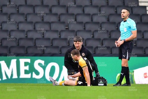 140226 - Milton Keynes Dons v Newport County - Sky Bet League 2 - Ciaran Brennan of Newport County is treated for an injury 