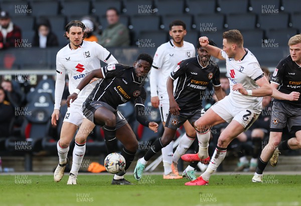 240224 - MK Dons v Newport County, EFL Sky Bet League 2 - Offrande Zanzala of Newport County  is challenged by Cameron Norman of MK Dons