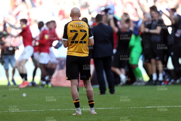 310521 - Morecambe v Newport County, SkyBet League 2 Play Off Final - A dejected Kevin Ellison of Newport County looks on as Morecambe manager Derek Adams and his team celebrate winning the play off trophy