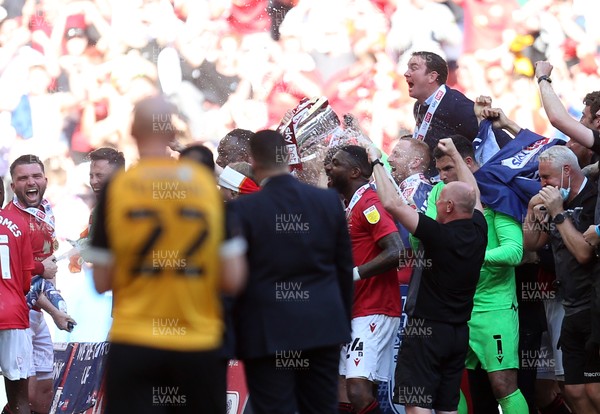 310521 - Morecambe v Newport County, SkyBet League 2 Play Off Final - A dejected Kevin Ellison of Newport County looks on as Morecambe manager Derek Adams and his team celebrate winning the play off trophy
