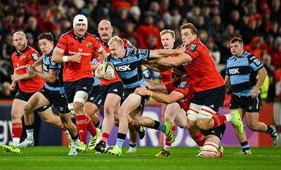 041025 - Munster v Cardiff Rugby, United Rugby Championship - Johan Mulder of Cardiff Rugby makes a break despite the efforts of Munster players Jean Kleyn, left, and Gavin Coombes
