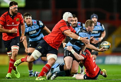 041025 - Munster v Cardiff Rugby, United Rugby Championship - Dan Thomas of Cardiff Rugby is tackled by Munster players Fineen Wycherley, left, and Ethan Coughlan
