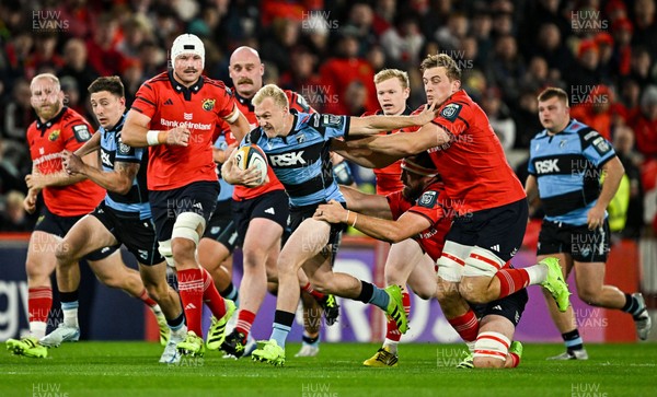 041025 - Munster v Cardiff Rugby, United Rugby Championship - Johan Mulder of Cardiff Rugby makes a break despite the efforts of Munster players Jean Kleyn, left, and Gavin Coombes