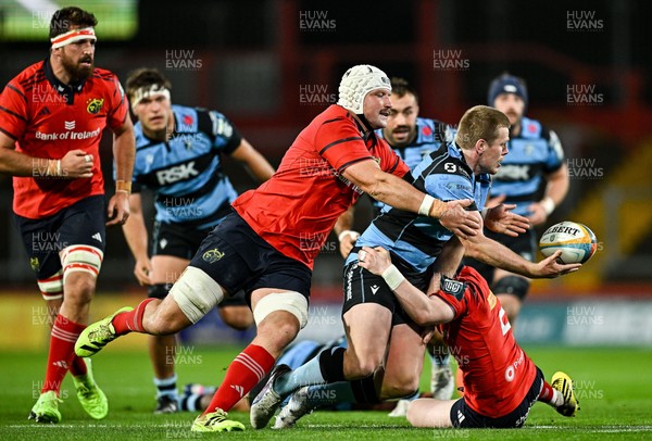 041025 - Munster v Cardiff Rugby, United Rugby Championship - Dan Thomas of Cardiff Rugby is tackled by Munster players Fineen Wycherley, left, and Ethan Coughlan