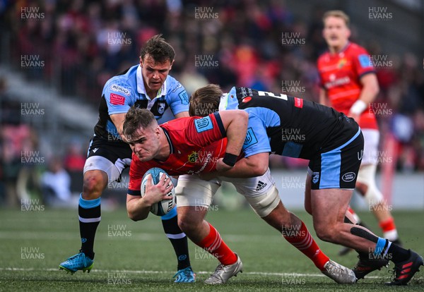 290422 - Munster v Cardiff Rugby - United Rugby Championship - Alex Kendellen of Munster is tackled by Jarrod Evans and Kristian Dacey of Cardiff