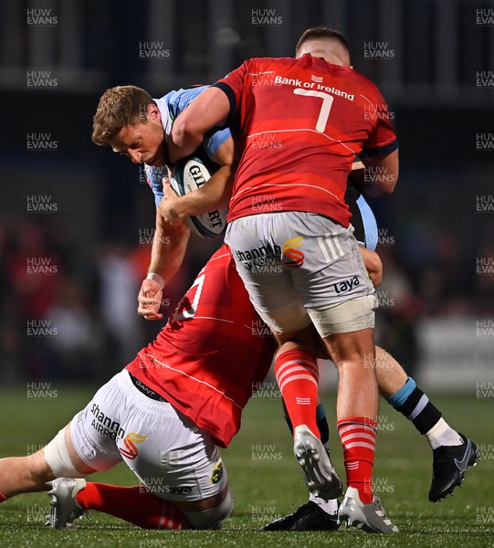 290422 - Munster v Cardiff Rugby - United Rugby Championship - Rhys Priestland of Cardiff is tackled by Jack Daly and Alex Kendellen