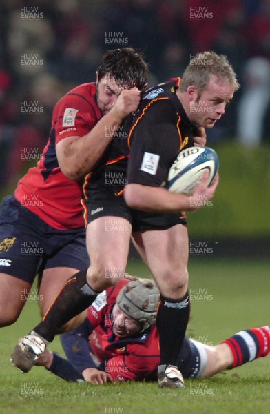 280106  Munster v Gwent Dragons  John Bryant is tackled by Tony Buckley and Anthony Kavanagh   