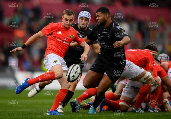 280919 -  Munster and Dragons - Guinness PRO14 -  Nick McCarthy of Munster kicks under pressure from Leon Brown of Dragons