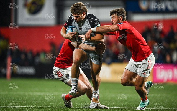 041123 - Munster v Dragons - United Rugby Championship - Jack Dixon of Dragons is tackled by Edwin Edogbo, left, and Alex Nankivell of Munster
