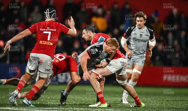 041123 - Munster v Dragons - United Rugby Championship - Taine Basham of Dragons is tackled by Brian Gleeson of Munster, left, and Tom Ahern of Munster