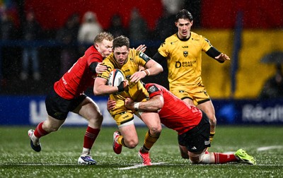 230126 - Munster v Dragons RFC - United Rugby Championship - Angus O'Brien of Dragons is tackled by Ethan Coughlan, left, and Diarmuid Barron of Munster